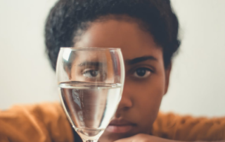 A woman looking at a glass of water